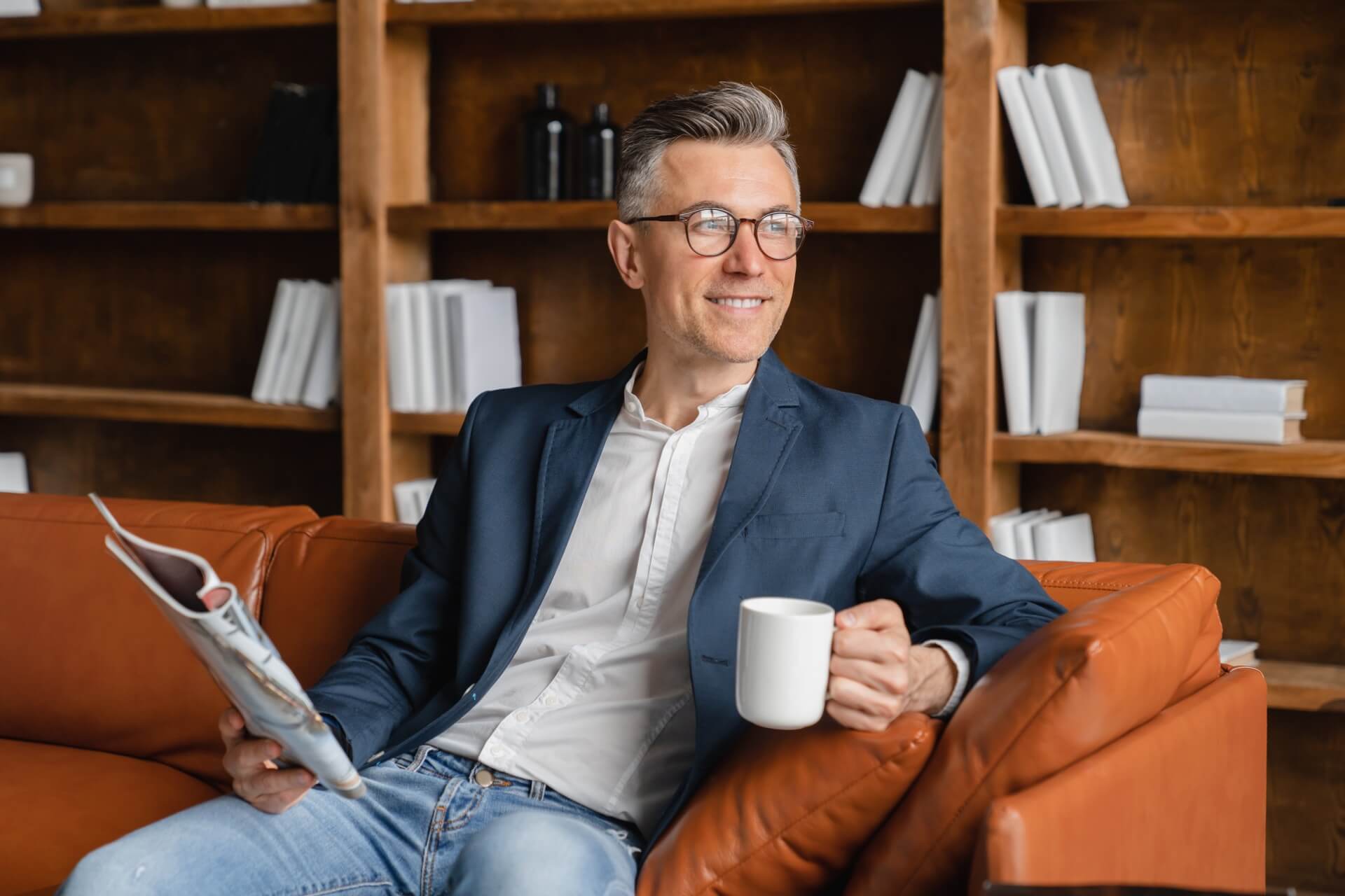 Business owner drinking coffee and looking out window because of noble digital wordpress design solutions