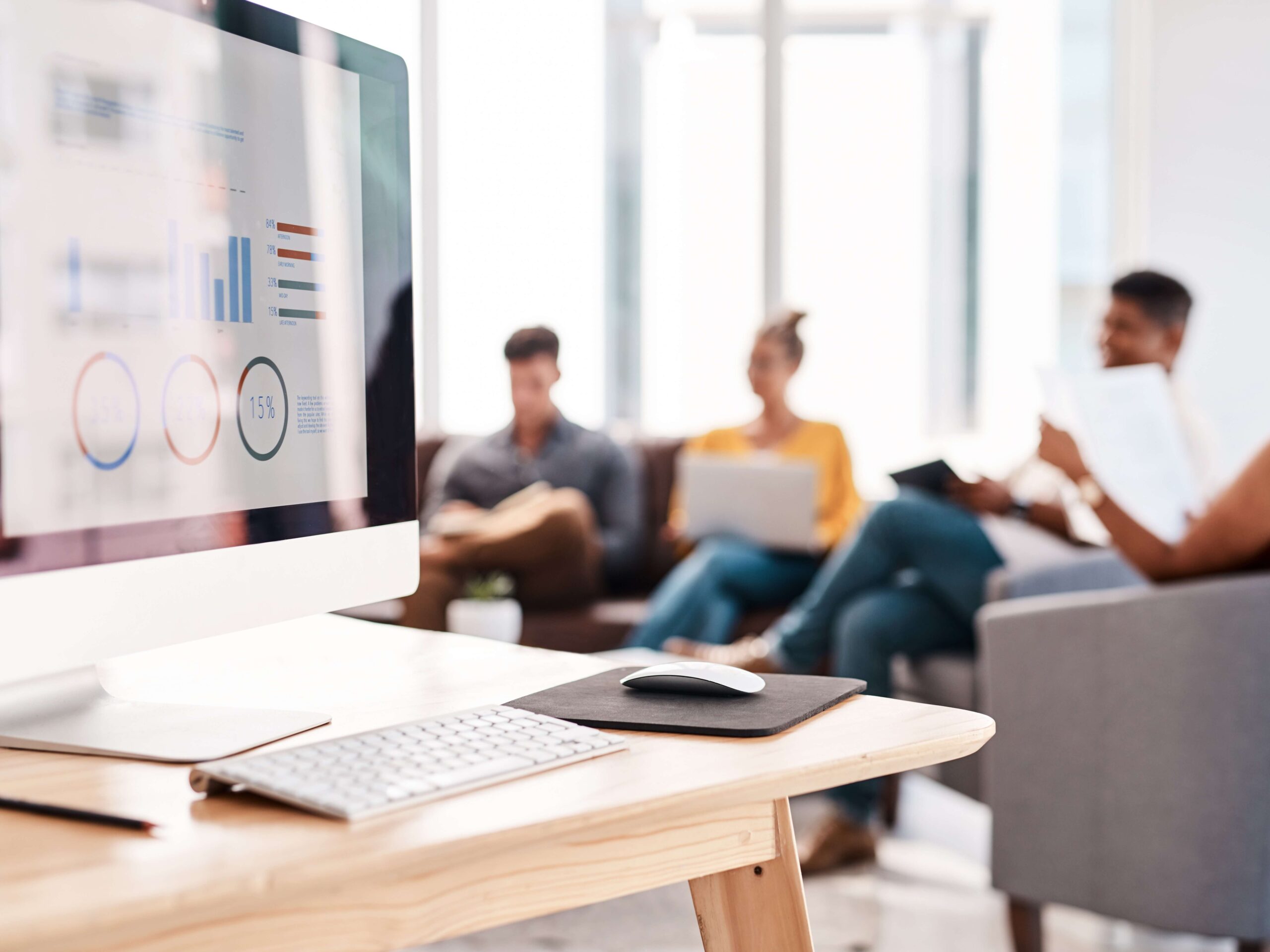 Office team in background discussing computer screen website update
