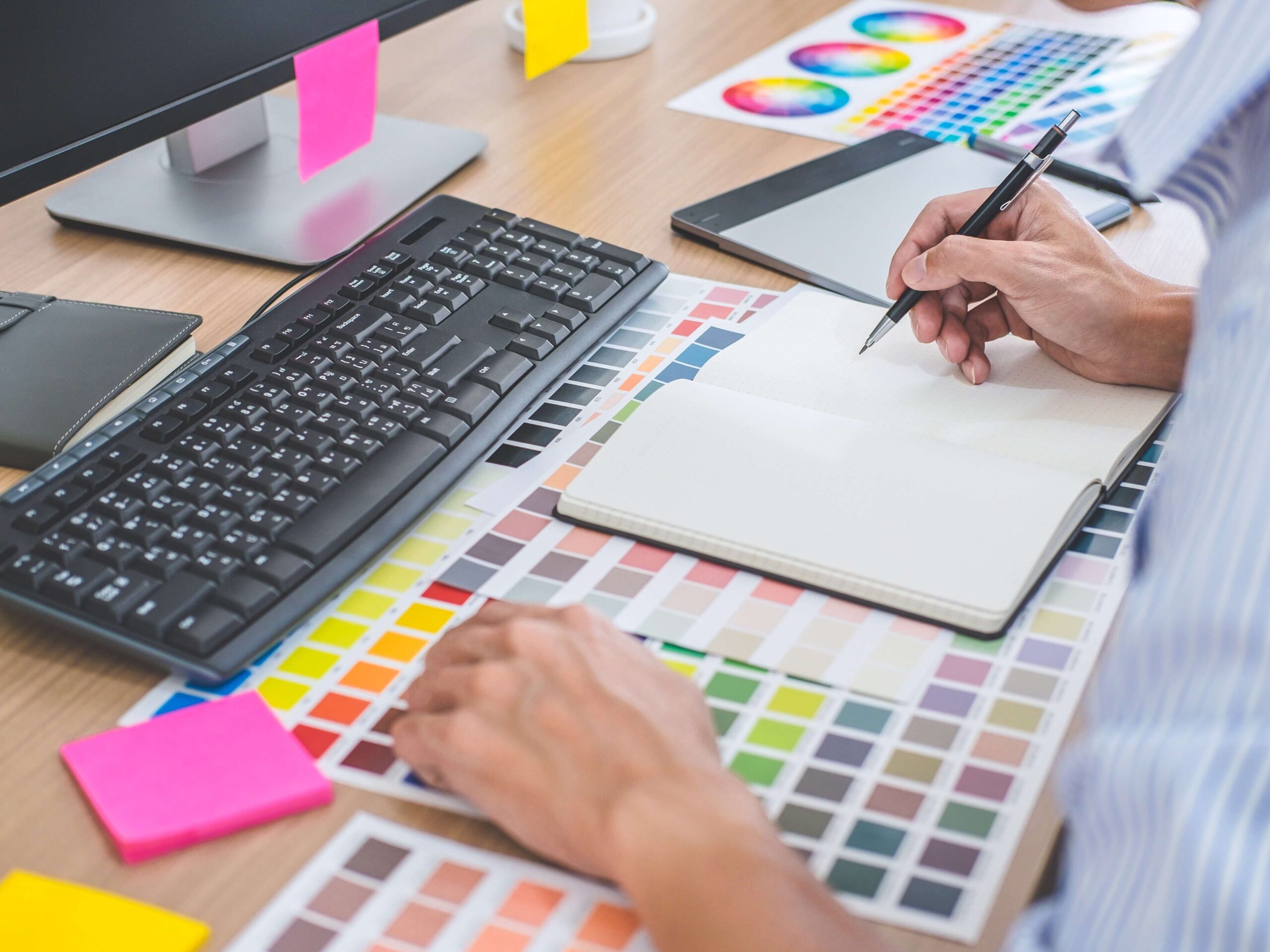 Computer with person working with colors on how often should you redesign your website